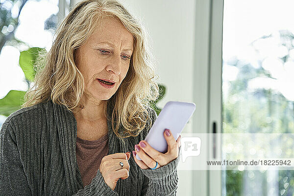 Senior woman checking e-mail inbox on smart phone