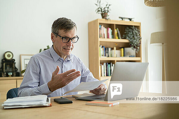Senior businessman having an online meeting while doing home office