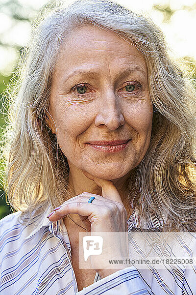 Confident senior woman looking at the camera with hand on chin