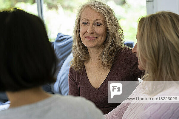 Portrait of senior woman chatting with her two friends at home