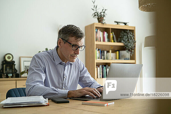 Senior businessman using laptop while working at home