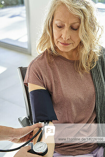 Senior woman measuring blood pressure by doctor