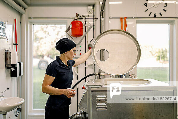 Farmer examining machine at dairy factory