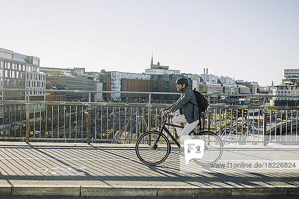 Geschäftsmann fährt Fahrrad auf Radweg gegen Gebäude in der Stadt