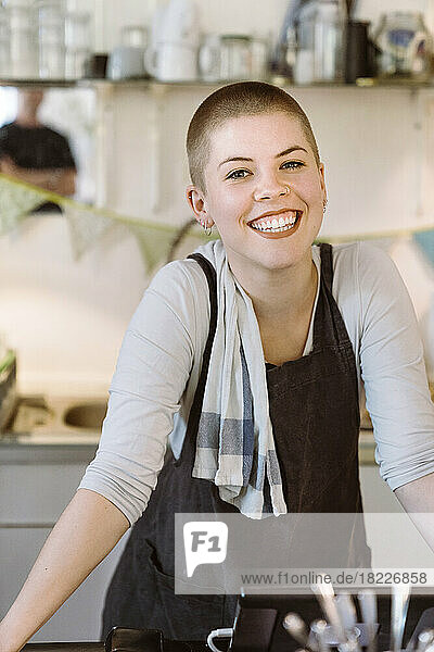Porträt einer glücklichen Besitzerin mit Schürze in einem Cafe