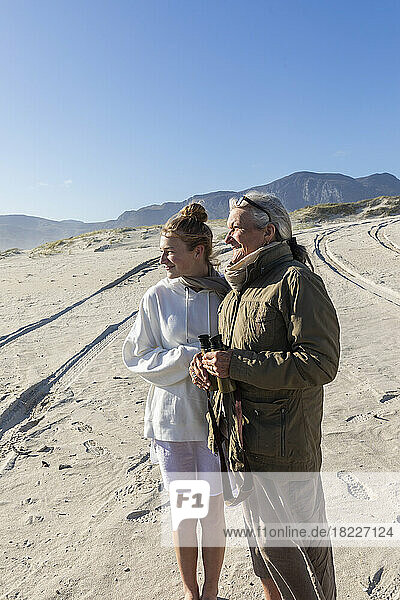 South Africa  Hermanus  Teenage girl (16-17) with grandmother walking on sand dune