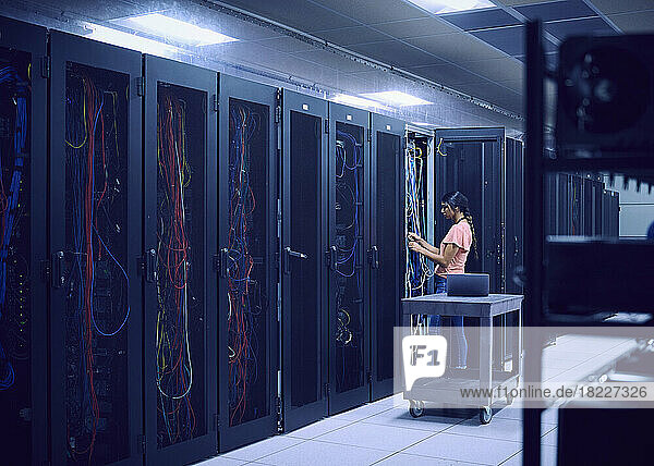 Female technician working in server room
