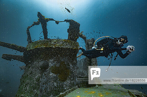 Diver exploring the wreck of the Sattakut close to Koh Tao