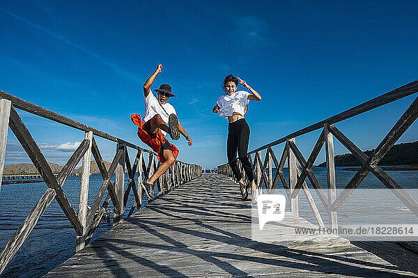 couple jumping on a pier at east Nusa Tenggara island in Komodo