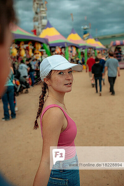 Teen girl talking to someone out of focus at a carnival