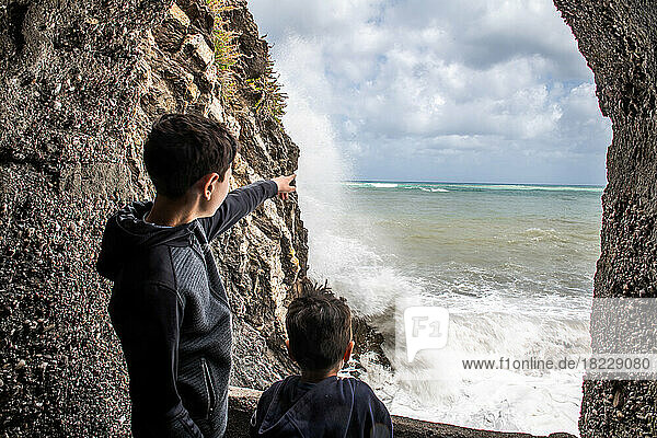Italy  Sicily  Boys (6-7  10-11) looking at?sea waves crashing