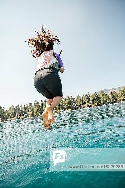 Woman jumping into lake