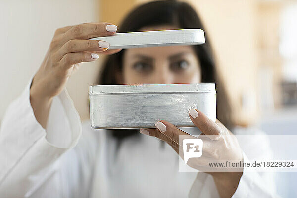 Scientist holding metal box  focus on foreground