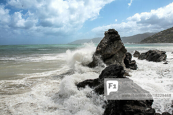 Italy  Sicily  Sea waves crashing on beach rocks