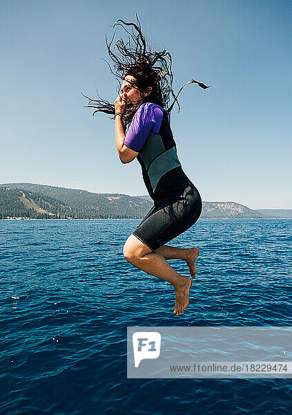 Woman jumping into lake