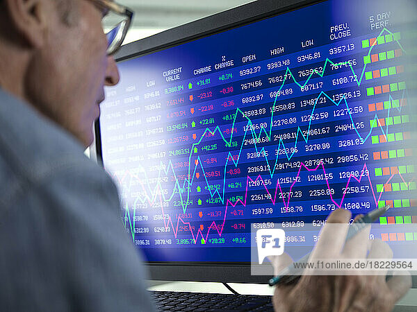 Stock trader viewing performance of shares on screen