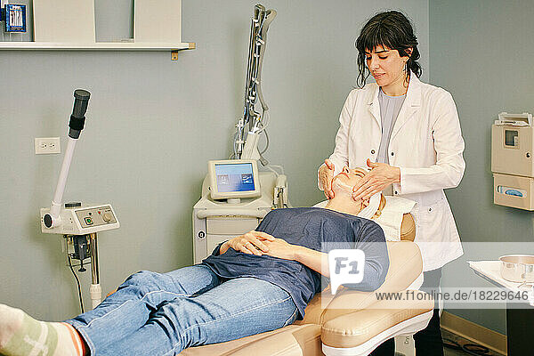 Beautician massaging patients face