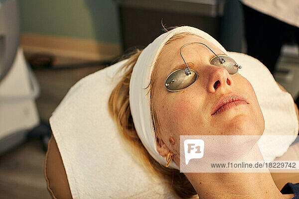 Close-up of woman with protective eyeglasses in beauty spa