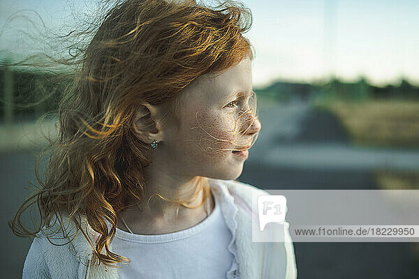 Thoughtful cute redhead girl with freckles  portrait