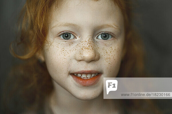 Smiling cute girl with freckles on face