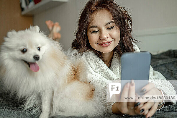 Happy woman using smart phone at home