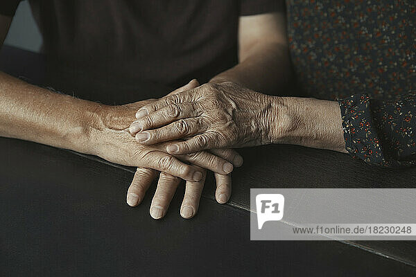 Älteres Paar stapelt die Hände auf dem Tisch