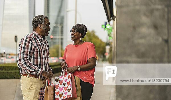 Senior couple with shopping bags talking to each other