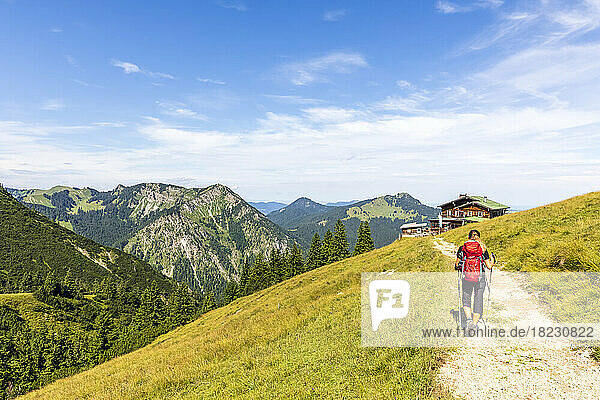 Germany  Bavaria  Female hiker following trail leading to alpine huts in Bavarian Prealps