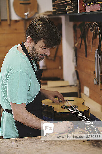 Luthier making flamenco guitar in workshop