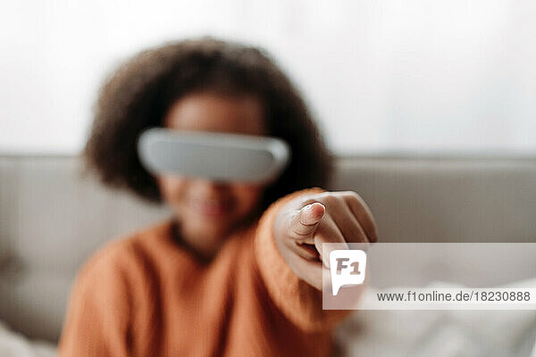 Girl with virtual reality simulator gesturing at home