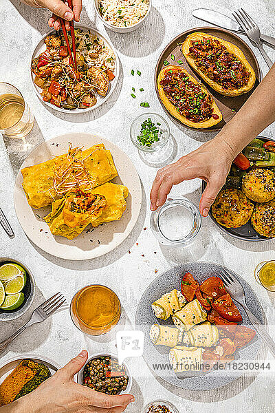 Der Tisch ist mit verschiedenen Gerichten gefüllt  darunter Chop Suey  gefüllte Kartoffeln  Fajitas  Reismuffins  Ricotta-Brötchen und verschiedene Salate