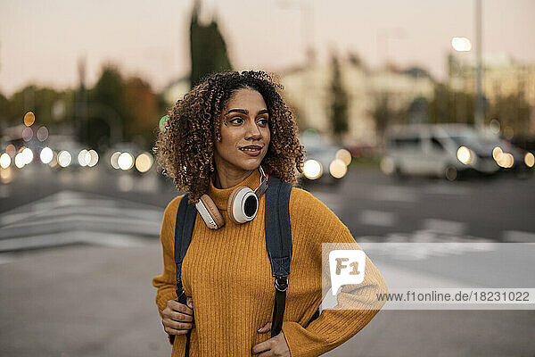 Beautiful young woman with backpack and wireless headphones