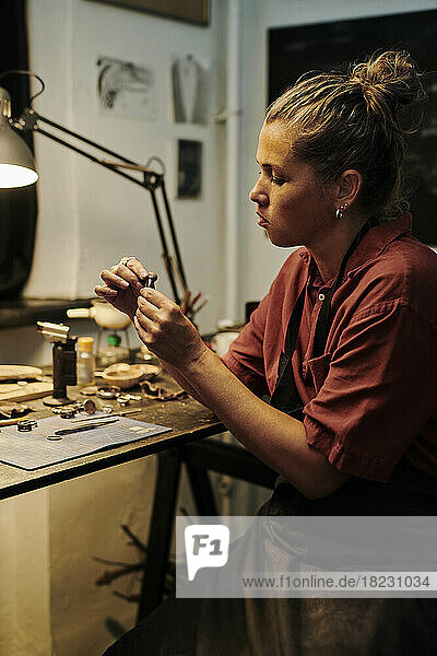 Craftswoman working at workbench in workshop