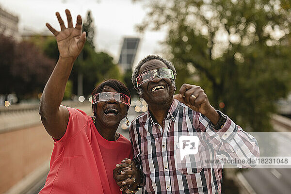 Happy senior couple enjoying with each other wearing smart glasses