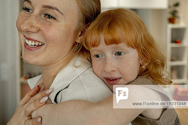 Happy daughter hugging mother at home