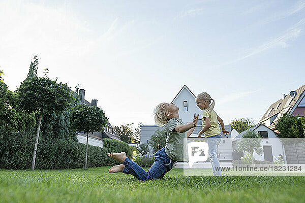 Girl with brother playing in garden