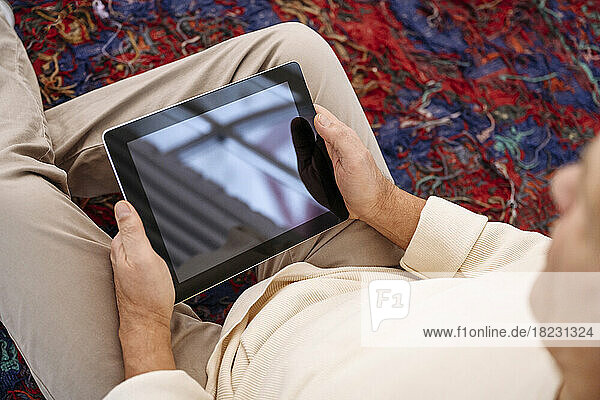 Senior man watching tablet PC at home