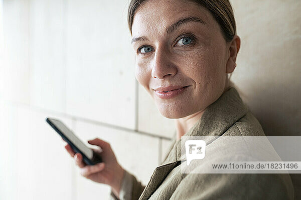 Smiling businesswoman with smart phone