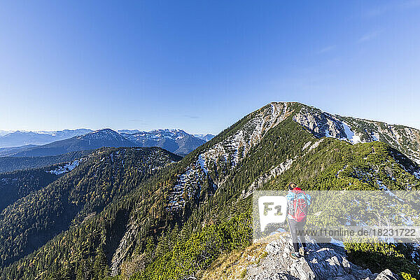 Germany  Bavaria  Female hiker admiring surrounding landscape from summit of Heimgarten mountain