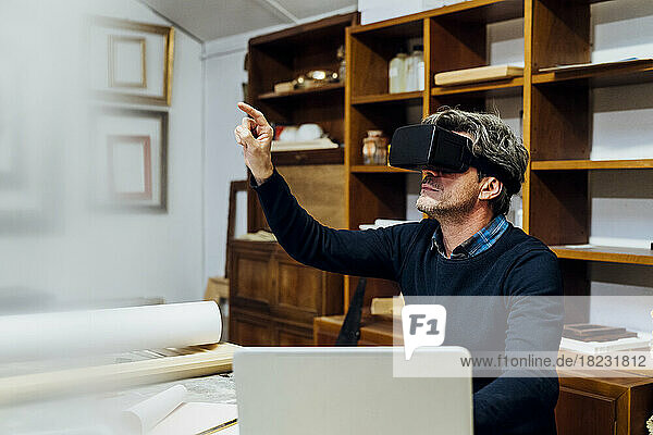 Mature craftsman using VR glasses in workshop