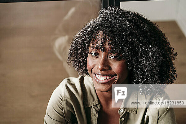 Smiling woman with curly hair at home