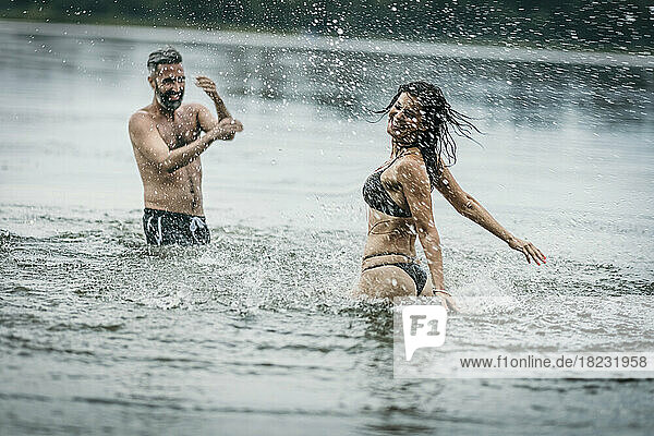 Happy mature man and woman having fun together in lake