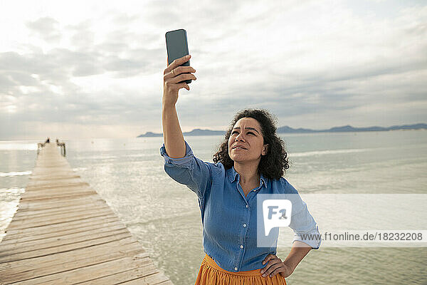 Woman searching mobile phone network on jetty