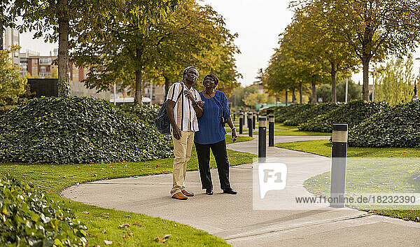 Senior man and woman standing on footpath at park