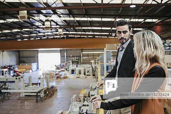 Businessman and businesswoman having discussion at industry