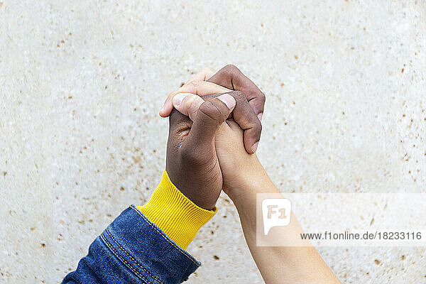 Man holding hand of woman in front of wall