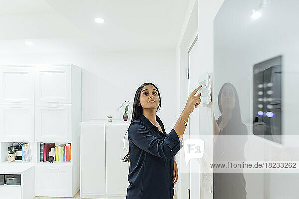 Woman using smart home device on wall