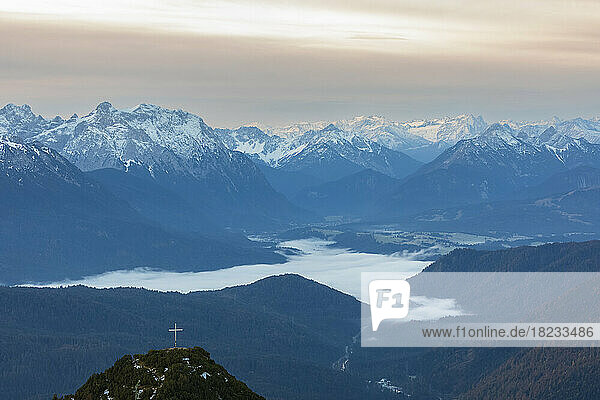 Germany  Bavaria  Foggy valley in Bavarian Prealps with summit cross in foreground