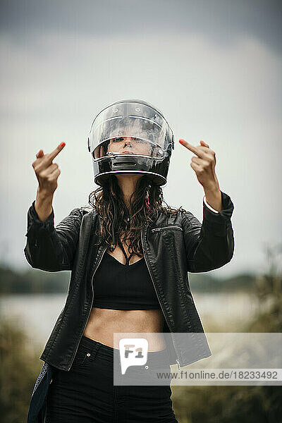 Woman wearing helmet showing middle fingers