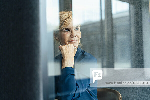 Contemplative businesswoman with hand on chin in soundproof cabin